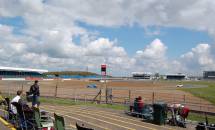 GT4 cars round Luffield and the new timing/scoring tower